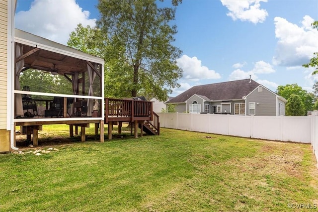 view of yard featuring a sunroom, fence, stairs, and a deck