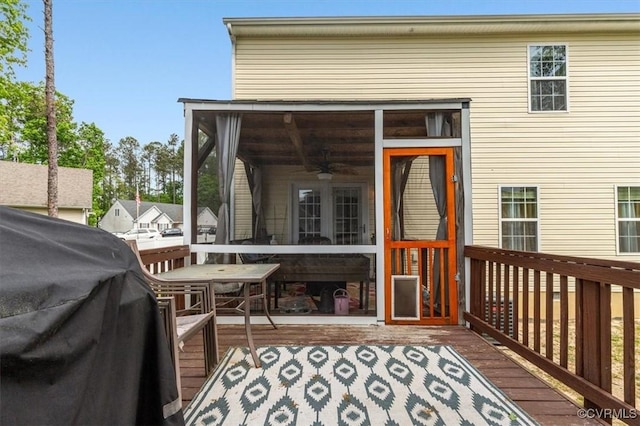 exterior space with a deck, a ceiling fan, and a sunroom