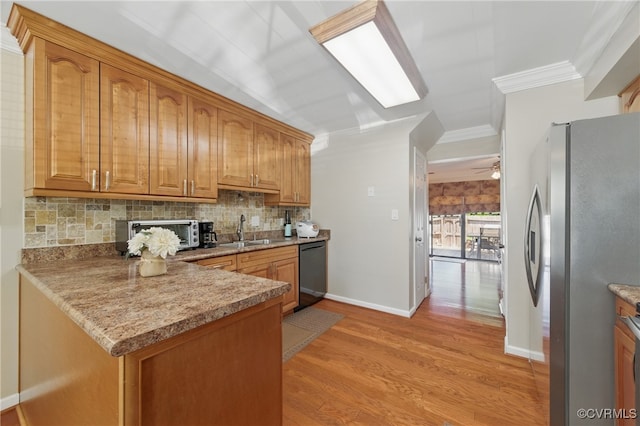 kitchen with backsplash, crown molding, a sink, freestanding refrigerator, and black dishwasher
