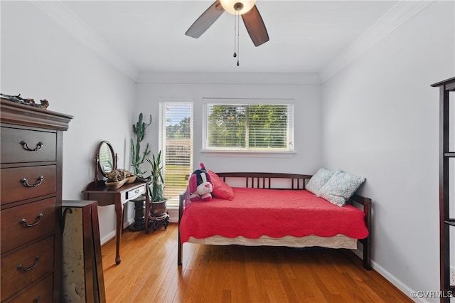 bedroom with crown molding, ceiling fan, baseboards, and wood finished floors