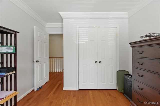 bedroom featuring crown molding, baseboards, a closet, and light wood finished floors