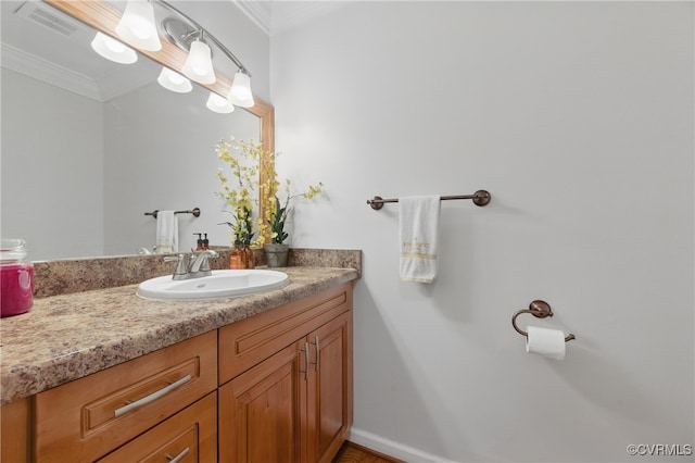 bathroom featuring crown molding, baseboards, visible vents, and vanity