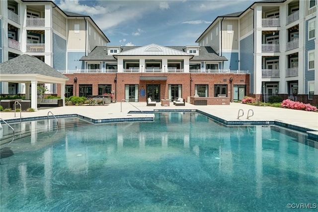 pool with a gazebo and a patio area