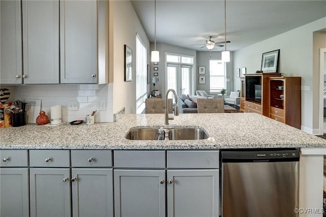 kitchen with a ceiling fan, light stone countertops, dishwasher, a sink, and gray cabinetry