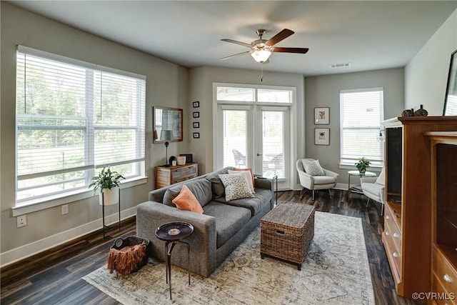 living area with a ceiling fan, baseboards, and plenty of natural light
