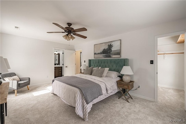 bedroom with carpet flooring, ceiling fan, a walk in closet, baseboards, and visible vents