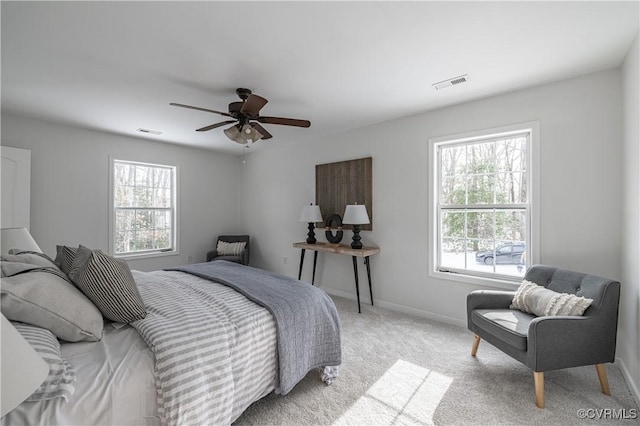bedroom featuring visible vents, multiple windows, and light colored carpet