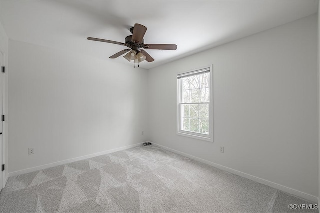 spare room featuring baseboards, ceiling fan, and light carpet