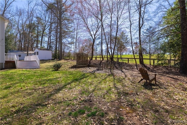 view of yard featuring a deck, an outbuilding, and a storage unit
