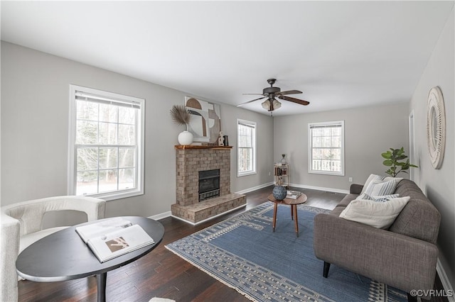 living room featuring baseboards, ceiling fan, wood finished floors, and a fireplace