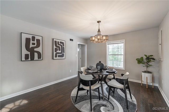dining area featuring baseboards, dark wood finished floors, and a chandelier