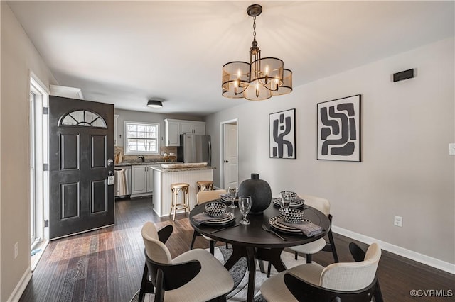 dining space featuring baseboards, dark wood-style flooring, and a chandelier