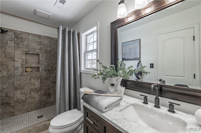 full bathroom featuring visible vents, a tile shower, toilet, and vanity