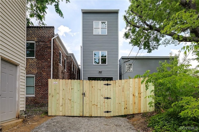 rear view of property with fence and a gate