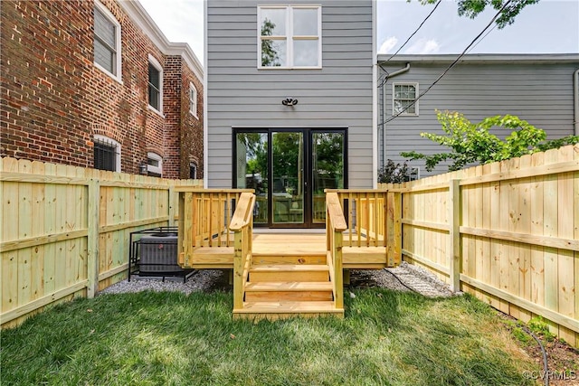 deck with a lawn, a fenced backyard, and central air condition unit