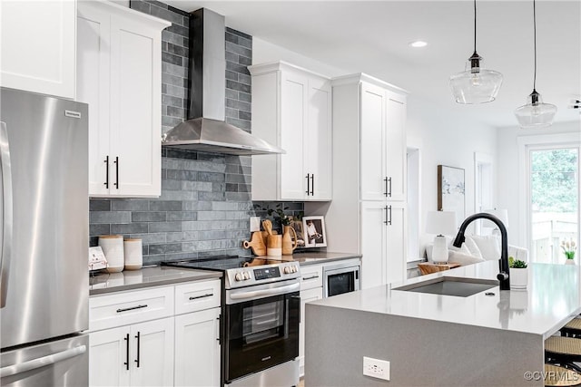 kitchen with a sink, appliances with stainless steel finishes, backsplash, and wall chimney range hood