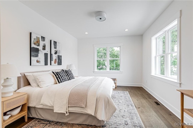 bedroom with visible vents, recessed lighting, baseboards, and wood finished floors