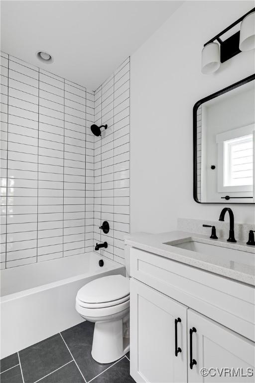 bathroom featuring toilet, shower / bathing tub combination, tile patterned flooring, and vanity