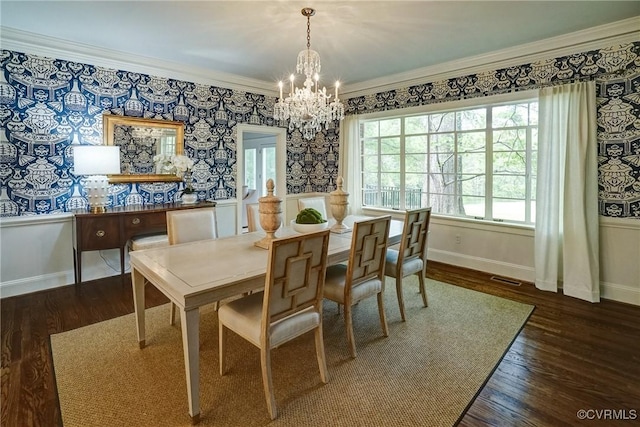 dining space with baseboards, wood finished floors, and an inviting chandelier