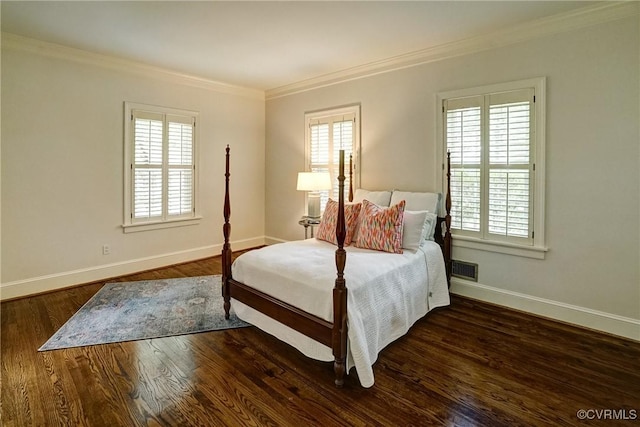 bedroom with crown molding, baseboards, wood finished floors, and multiple windows