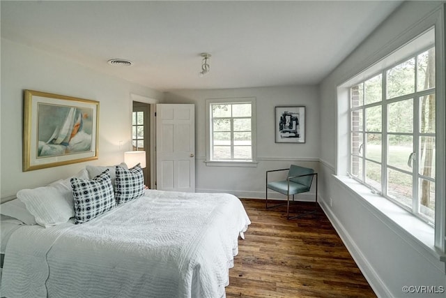 bedroom featuring visible vents, dark wood-style flooring, and baseboards