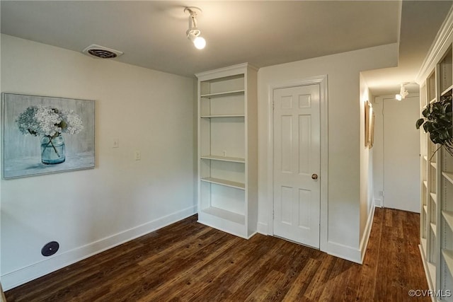 unfurnished bedroom featuring baseboards, visible vents, dark wood finished floors, and a closet