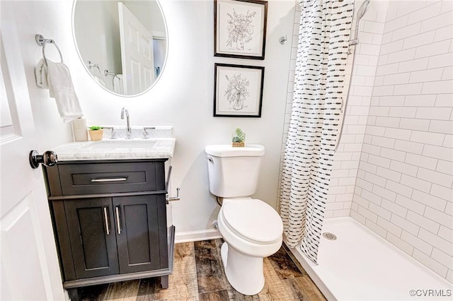 bathroom featuring vanity, toilet, and a stall shower
