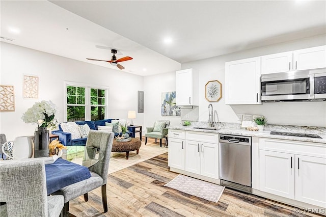 kitchen with a sink, light wood-style flooring, stainless steel appliances, a ceiling fan, and white cabinetry