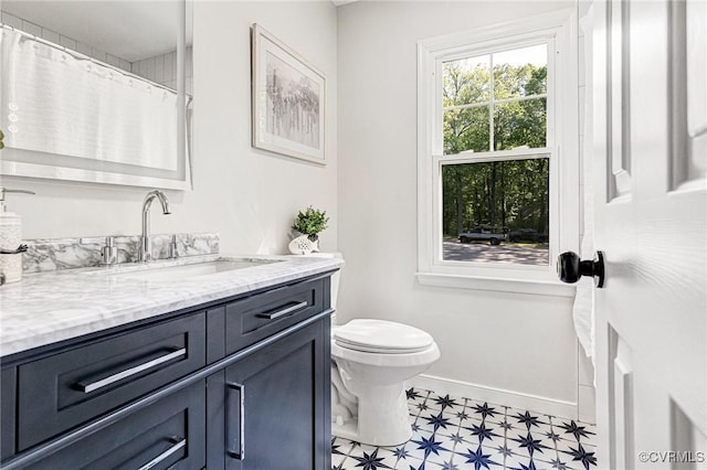 bathroom with vanity, toilet, tile patterned floors, a shower with shower curtain, and baseboards