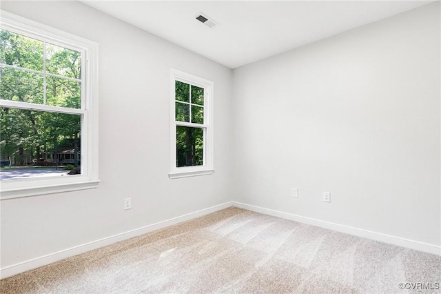 unfurnished room featuring baseboards, visible vents, and carpet