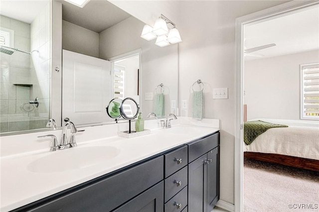 ensuite bathroom featuring a sink, a tile shower, ensuite bath, and double vanity