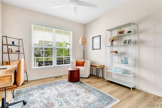 sitting room with baseboards, ceiling fan, wood finished floors, and visible vents