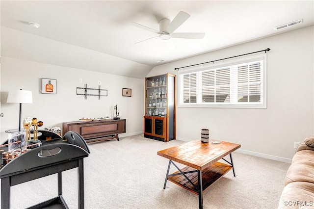 carpeted living room featuring vaulted ceiling, baseboards, a ceiling fan, and visible vents
