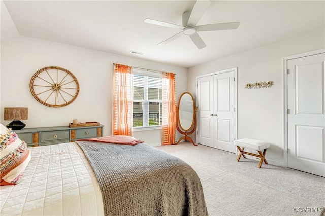 bedroom with ceiling fan, visible vents, light colored carpet, baseboards, and a closet