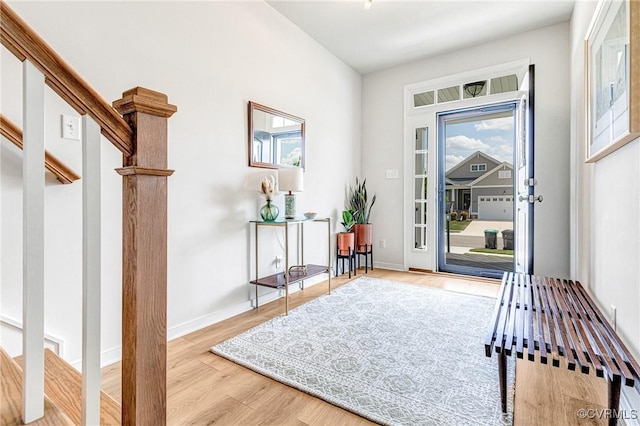 foyer entrance with baseboards, a wealth of natural light, and wood finished floors