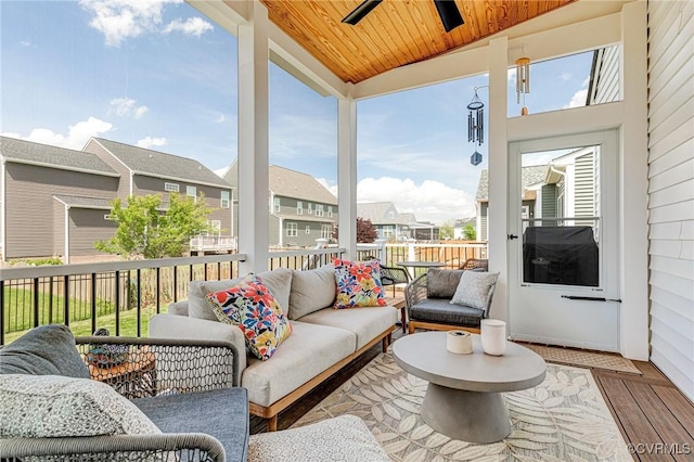 sunroom / solarium featuring a ceiling fan, outdoor lounge area, and a residential view