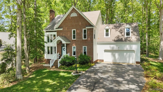 colonial house with a garage, a front lawn, aphalt driveway, roof with shingles, and a chimney