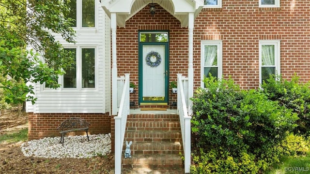property entrance featuring brick siding