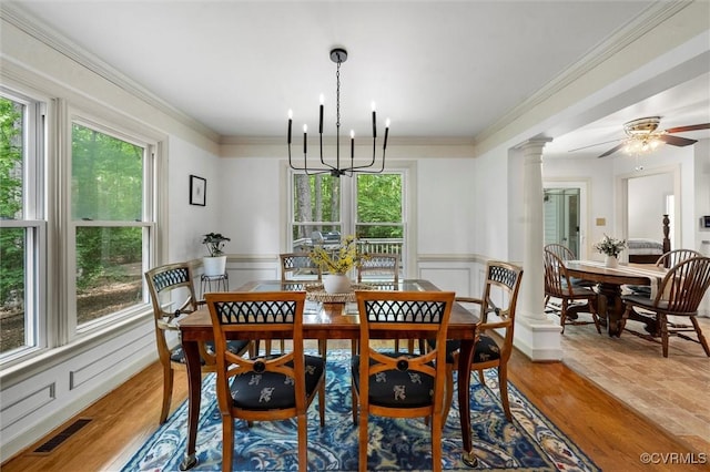 dining area with visible vents, ornamental molding, wainscoting, and an inviting chandelier