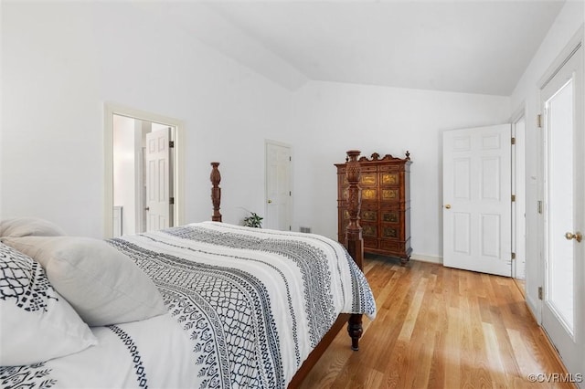 bedroom with light wood finished floors and vaulted ceiling