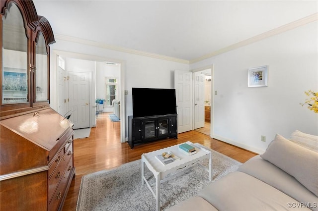 living area with baseboards, ornamental molding, and wood finished floors