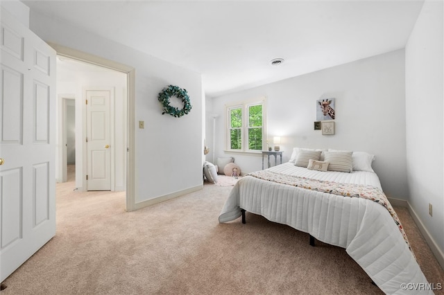 bedroom with baseboards, visible vents, and light carpet