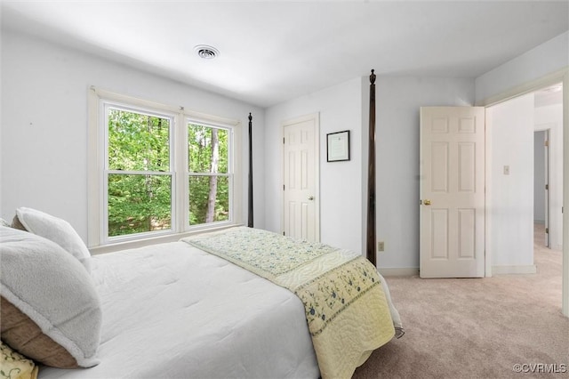 bedroom with baseboards, light carpet, and visible vents