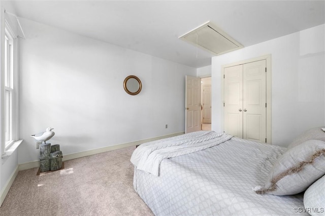 bedroom featuring carpet floors, attic access, baseboards, and a closet