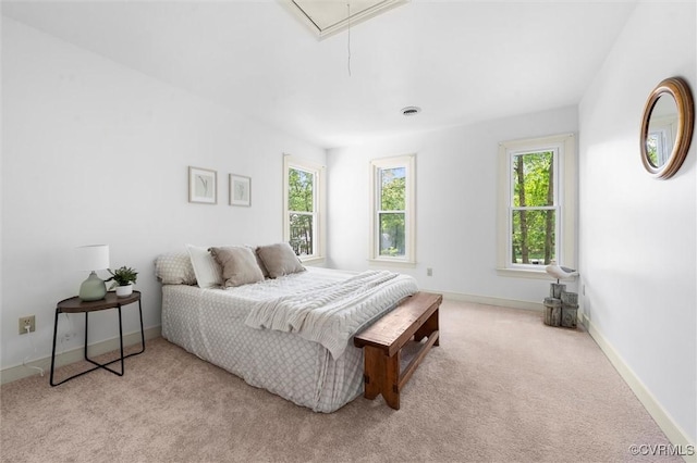bedroom with baseboards, attic access, and light colored carpet
