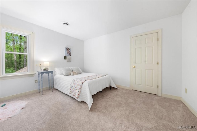 bedroom with carpet floors, baseboards, and visible vents