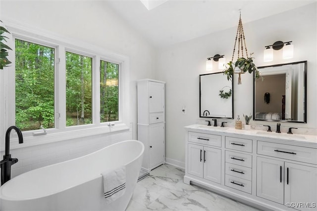 bathroom featuring double vanity, a sink, marble finish floor, and a healthy amount of sunlight
