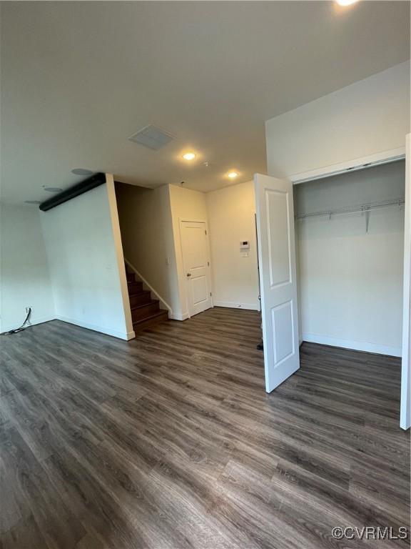 basement featuring stairs, recessed lighting, baseboards, and dark wood-style floors