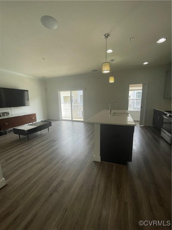 kitchen featuring pendant lighting, light countertops, stainless steel gas range, dark wood-style floors, and open floor plan