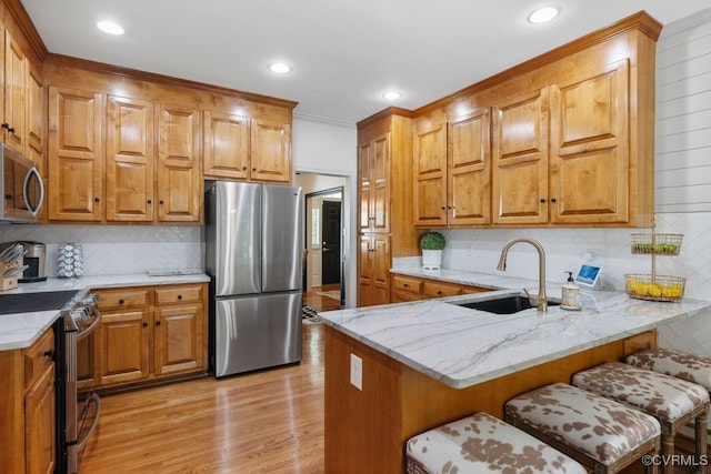 2951 W Maple Grove Ln, Powhatan, VA 23139 - kitchen featuring appliances with stainless steel finishes, a sink, a peninsula, decorative backsplash, and a breakfast bar area